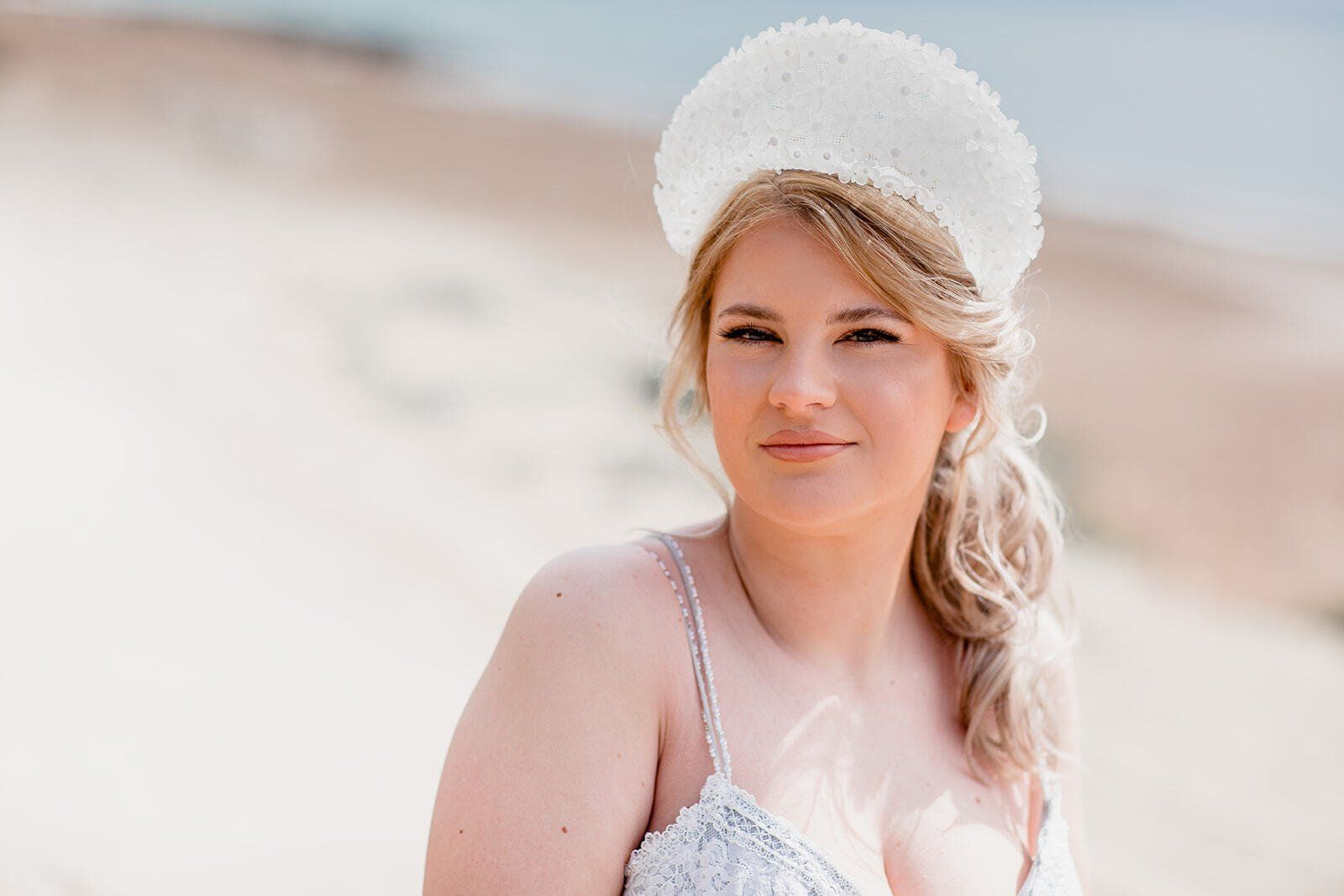 Head shot of Bride wearing a statement headcrown on Highcliffe Beach in Dorset