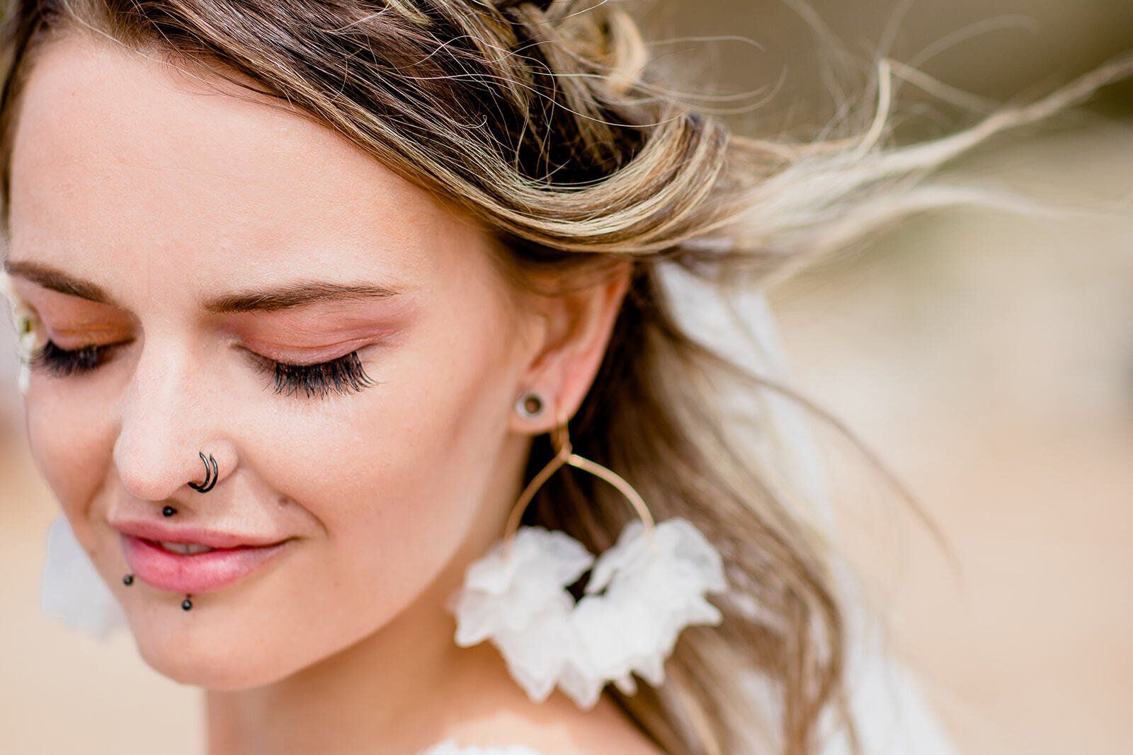 Close up of bridal make-up with piercings and statement earrings