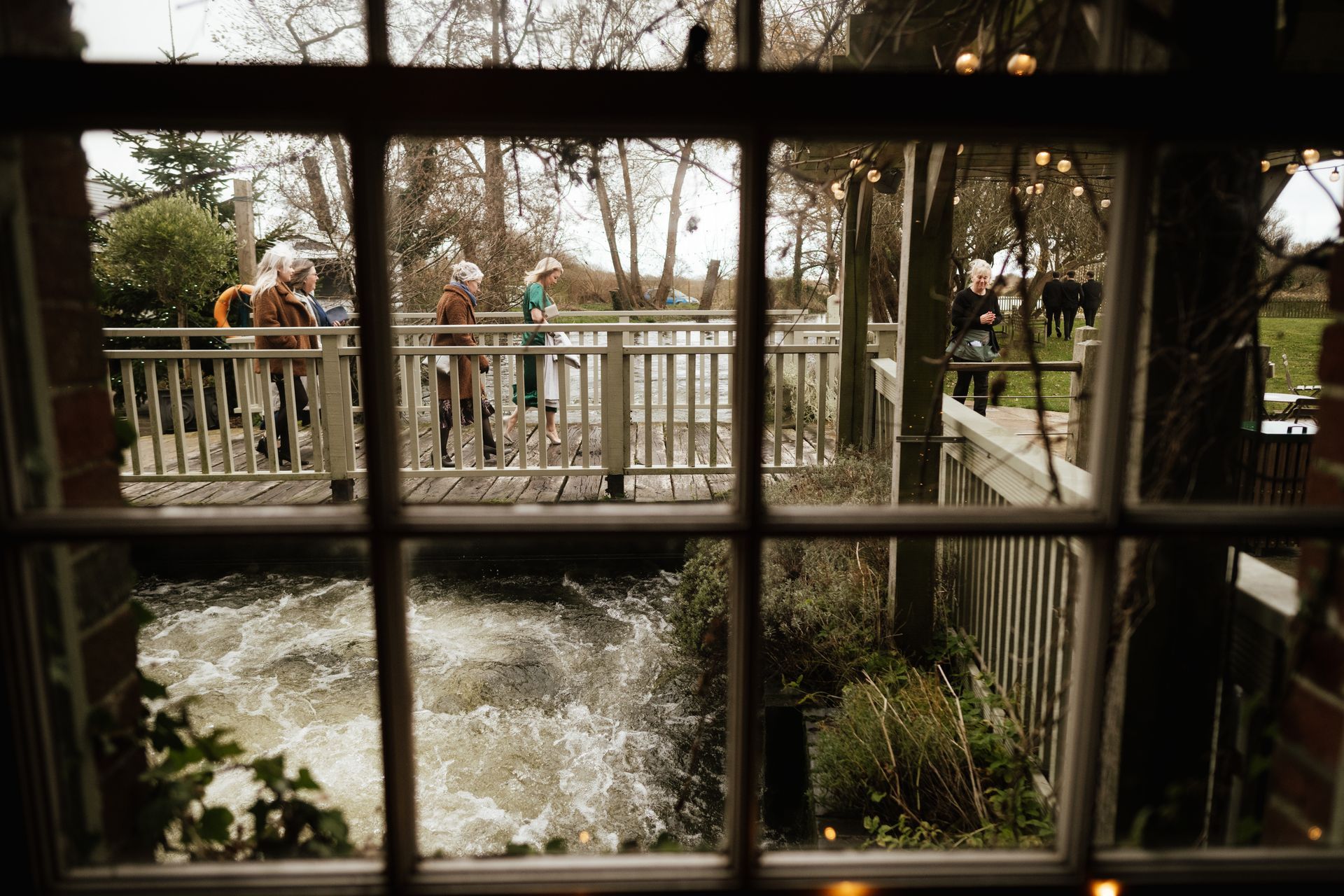 Guests arriving over the mill bridge at Sopley Mill ready for a wedding with Tasha Mae Wedding Co-ordinator.