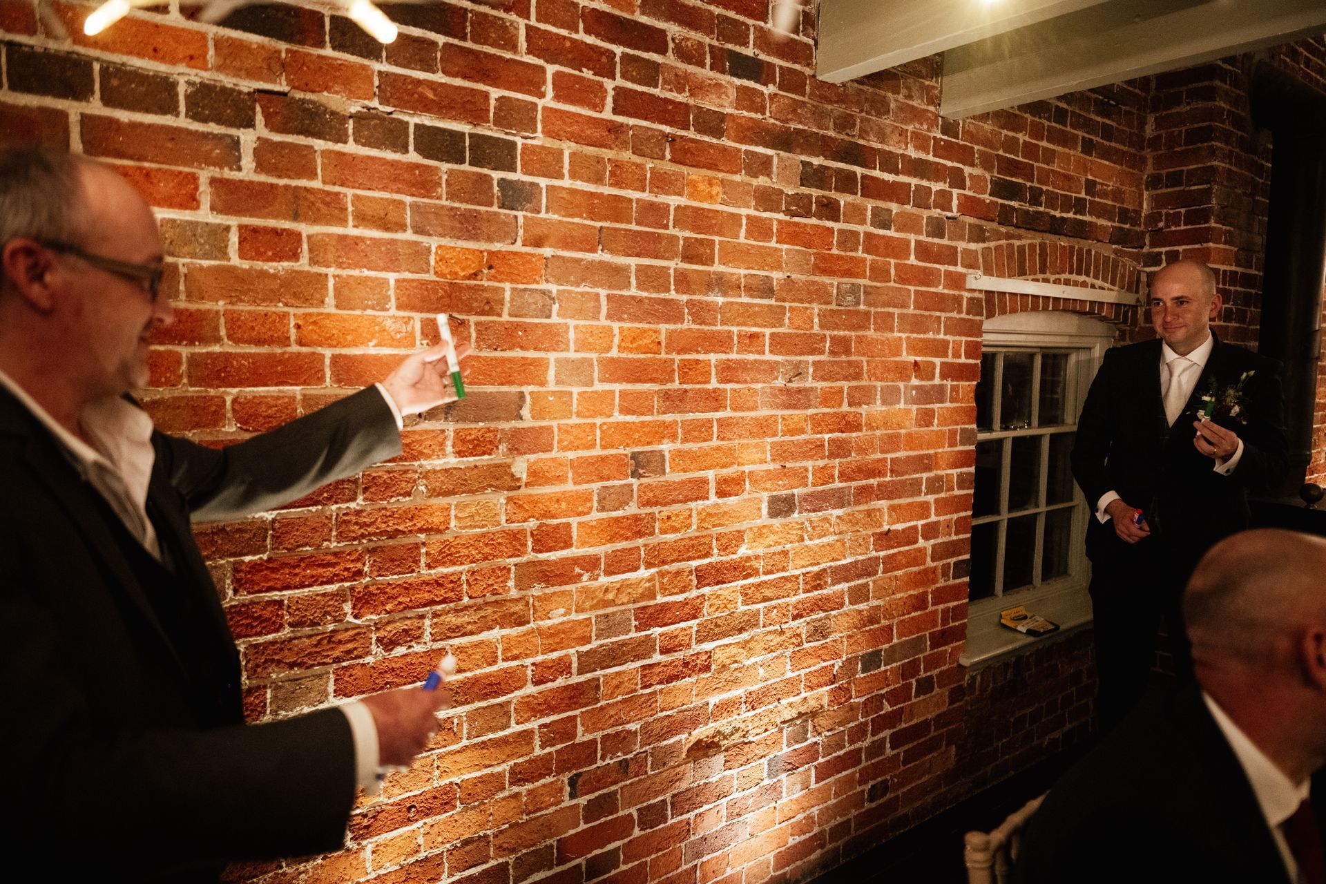 A magician playing a trick on the groom at his wedding at Sopley Mill with Tasha Mae Wedding Co-ordinator.