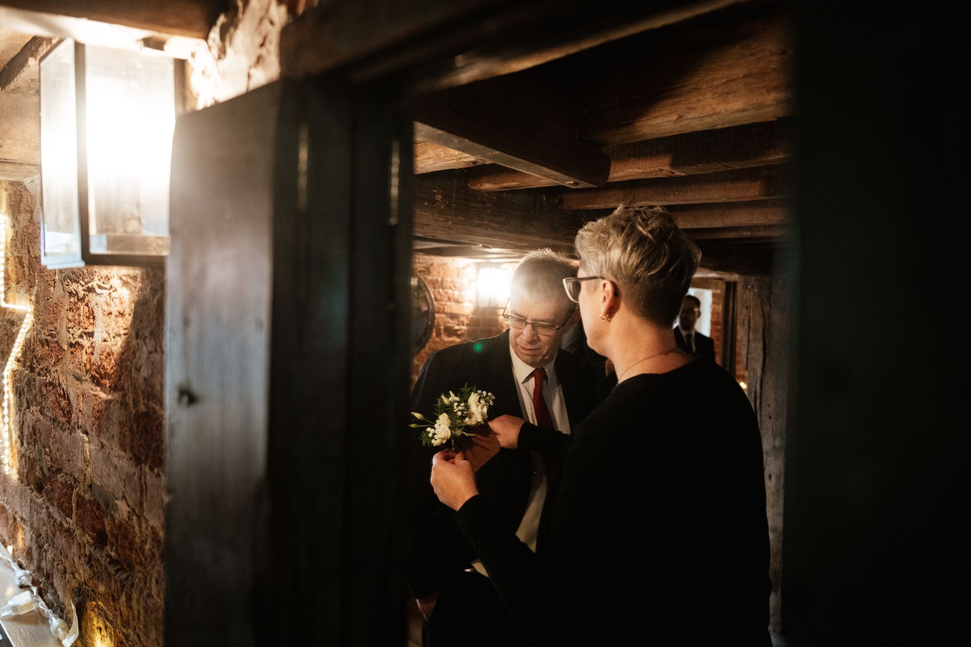 Tasha Mae Wedding Co-ordinator helping a father of the bride put their button hole on at Sopley Mill in Dorset.