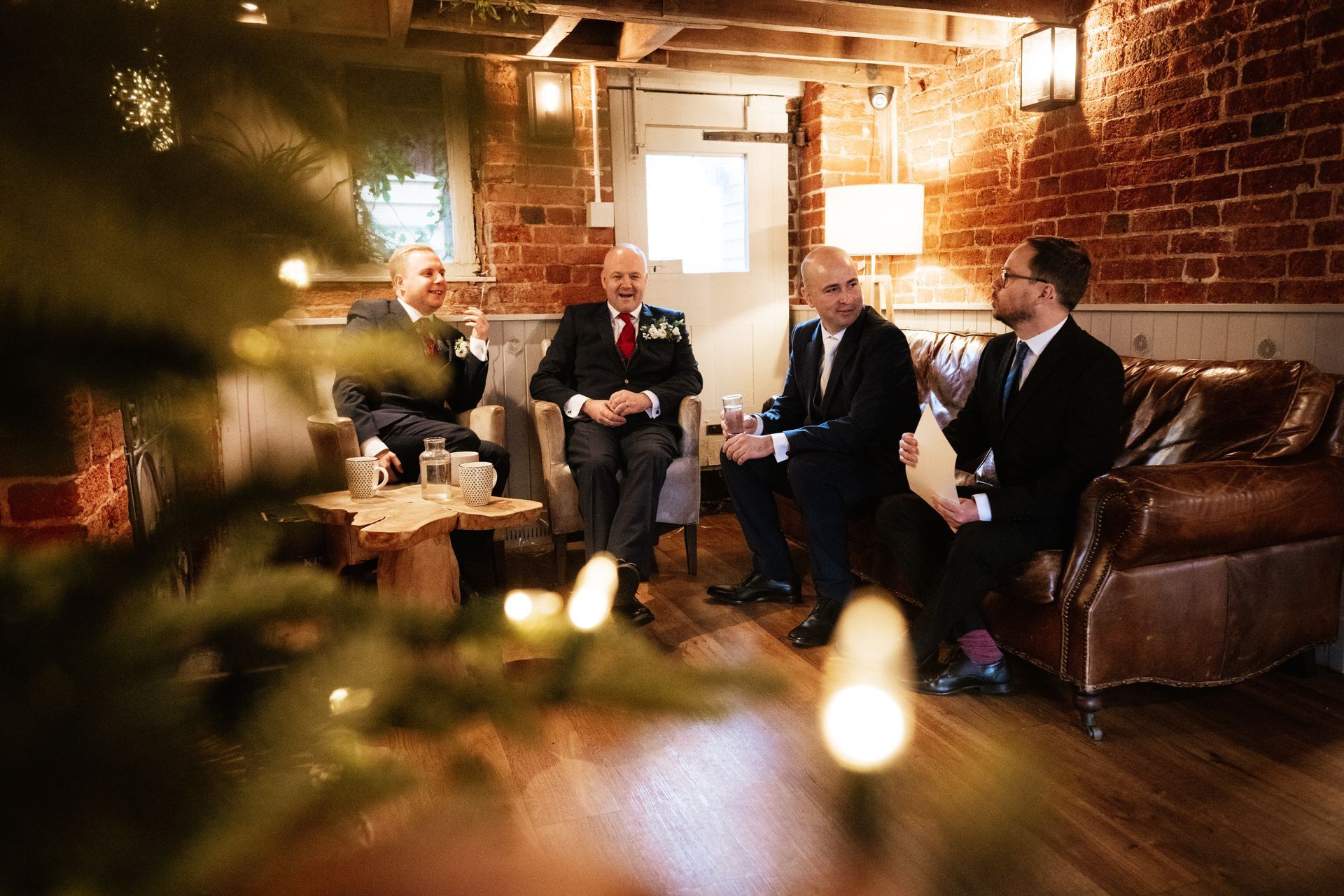 A groom and his groomsmen sat on a sofa before the ceremony at a wedding at Sopley Mill with Tasha Mae Wedding Co-ordinator.
