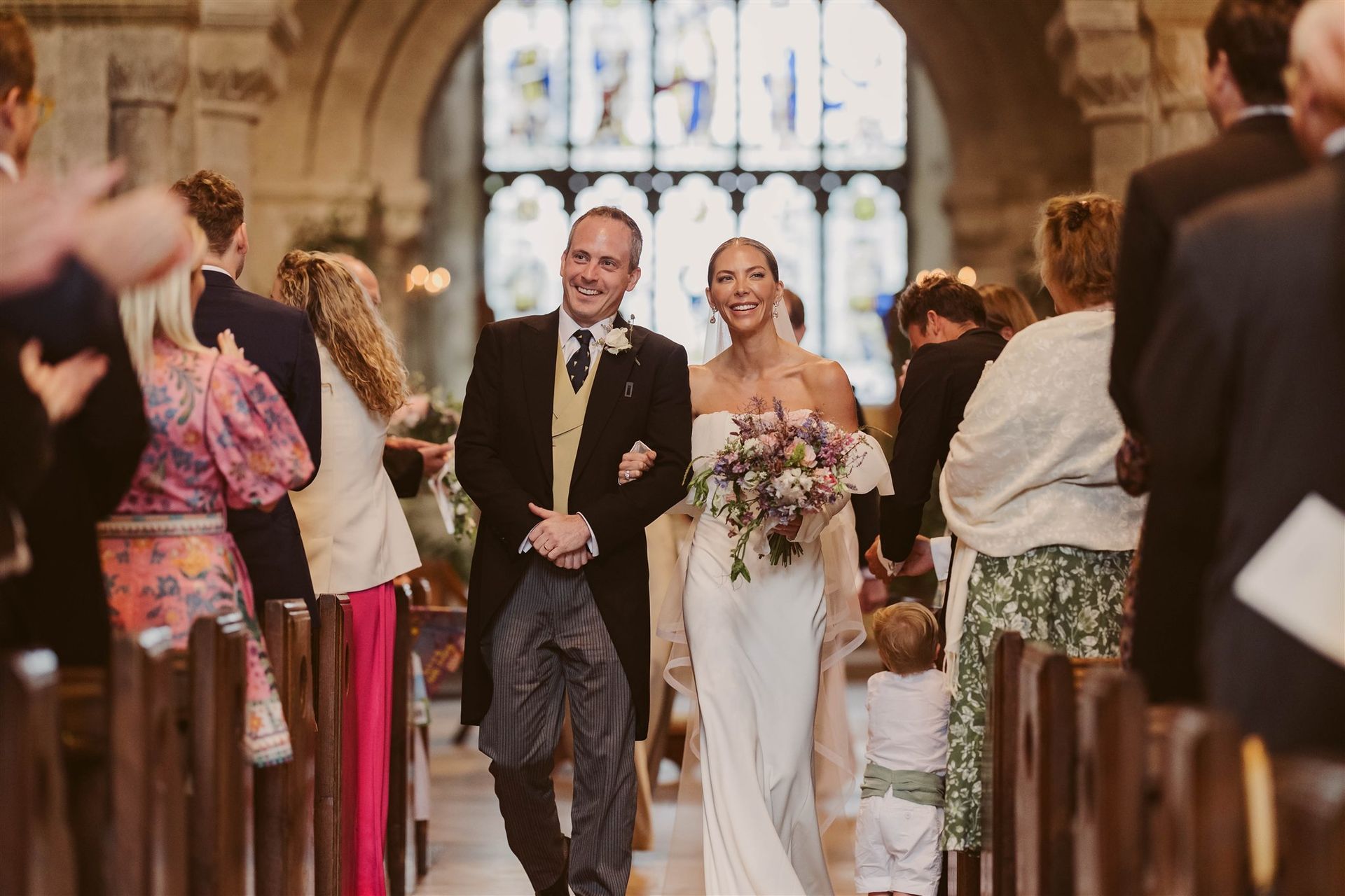 Bride and Groom walking back up the aisle in a church after getting married - co-ordinated by Tasha Mae Wedding Co-ordinator.