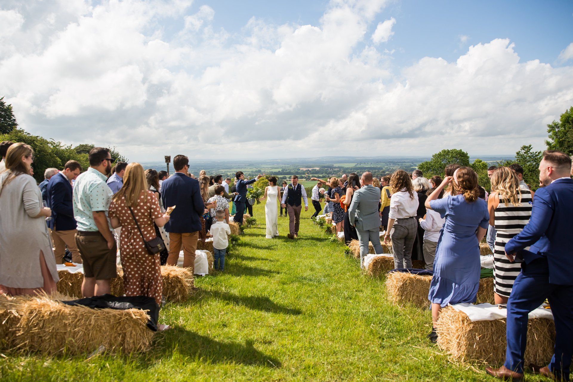 Bride & Groom walking up an outdoor wedding aisle in Oxford