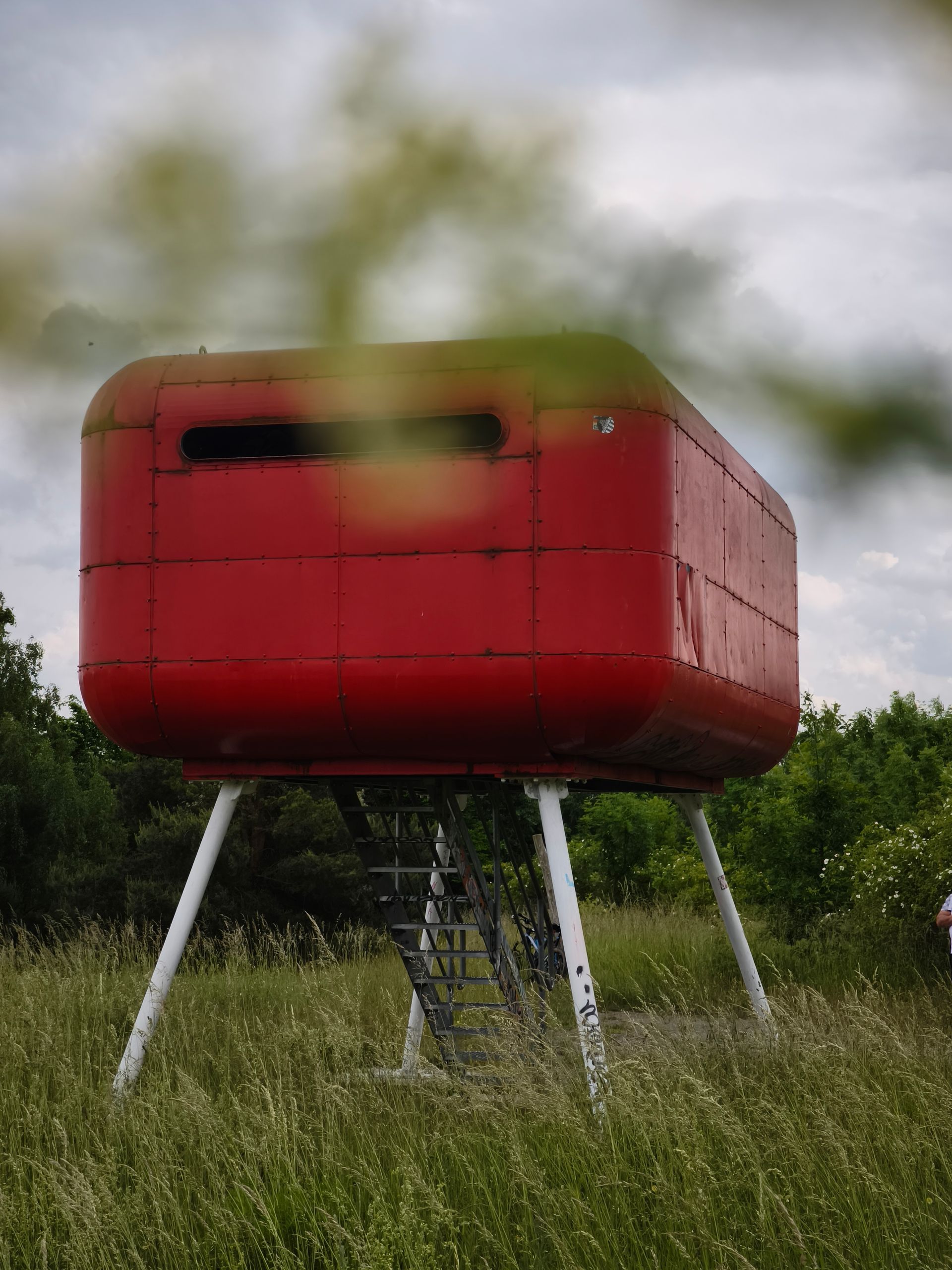 rote Aussichtsplattform „Rote Büchse“ am Gremminer See. Im Hintergrund weite Landschaft und Himmel.