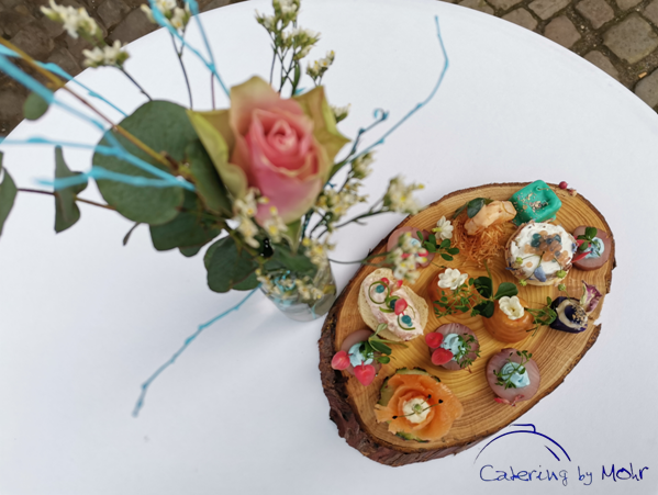 Fingerfood Frühling auf Holzbrett mit Blume