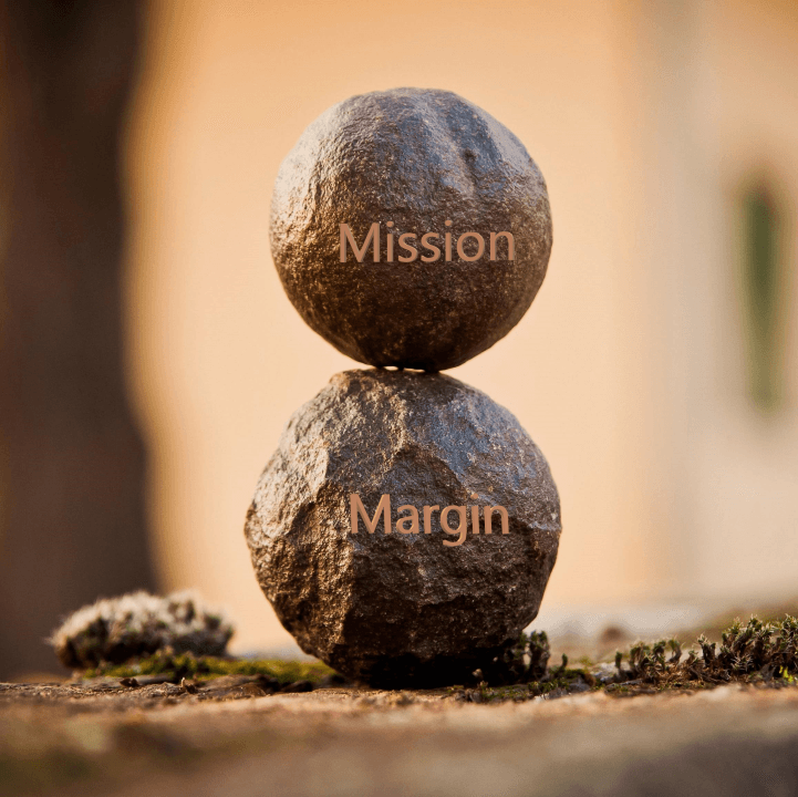 Two round rocks balancing. On top is the word Mission on the bottom is the word Margin