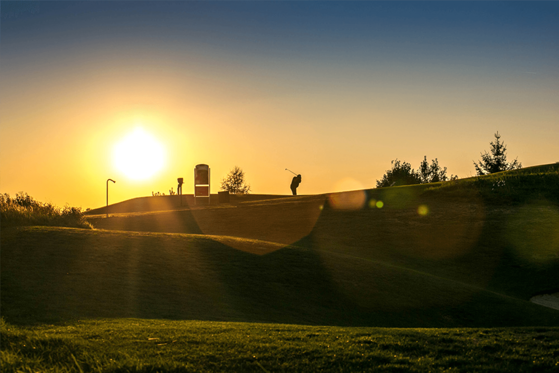 Golfer im Sonnenuntergang am 18 Loch des Fuerstlichen Golf- und Natur-Resorts Bad Waldsee