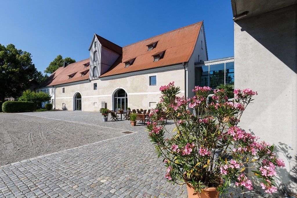 Liebevoll restauriertes Hofgut‑Gebäude – Fachwerk im Sonnenlicht.