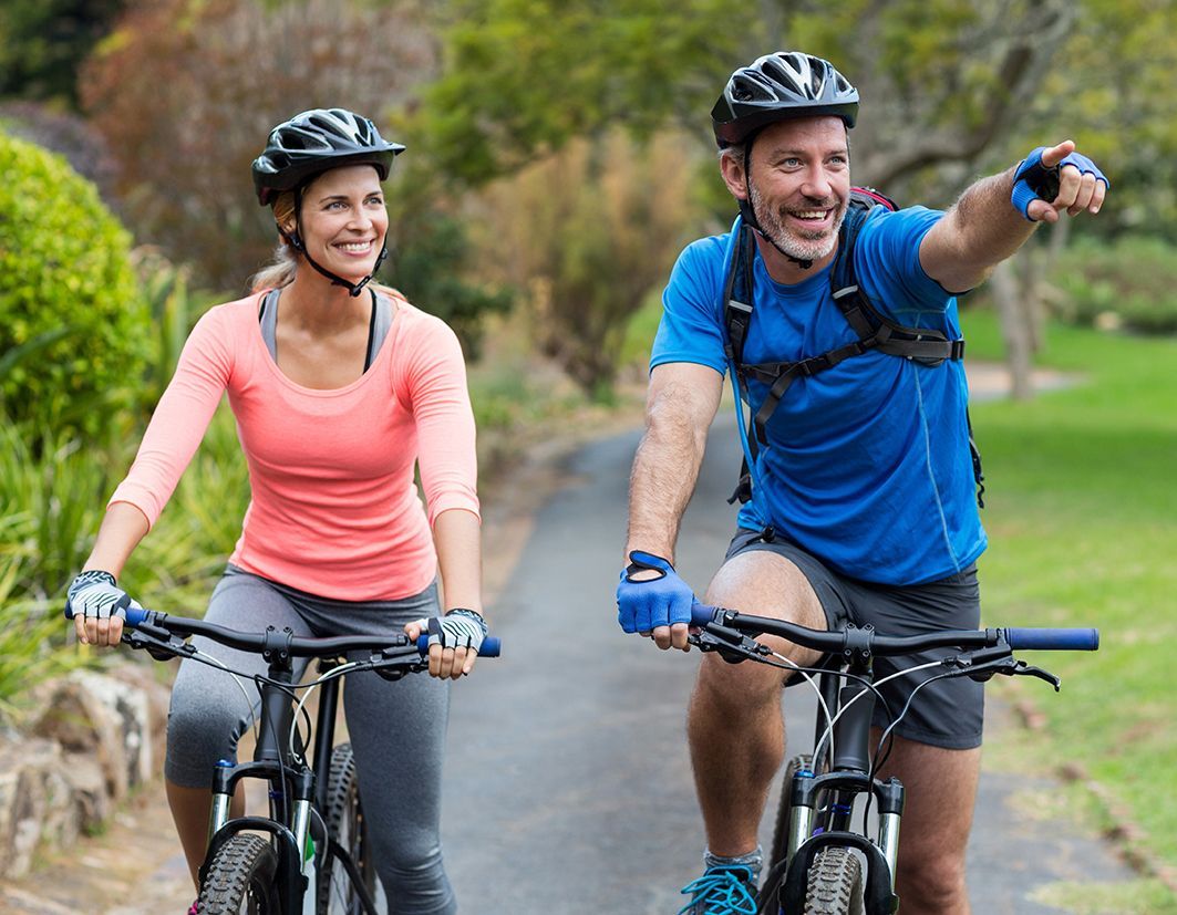 Zwei Biker, Mann und Frau auf E-Bikes, Mann mit blauem T-Shirt und Frau mit Top in lachsfarben
