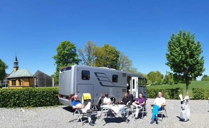 Camper vor ihrem Wohnmobil auf Stellplatz