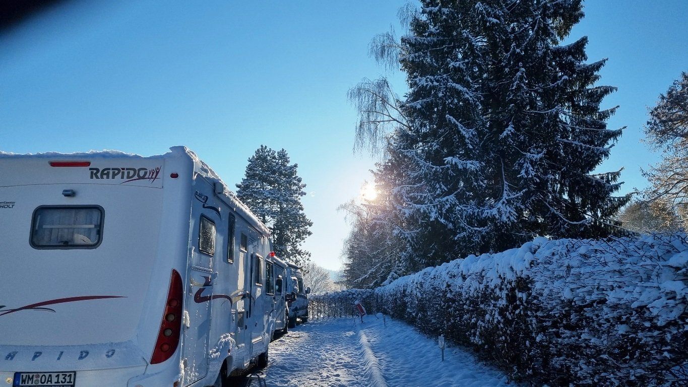 Wohnmobil von der Seite im Schnee bei Sonnenschein