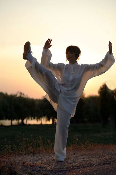 Tai Chi Übung,  rechtes Bein heben und Arme zur Seite aufstellen