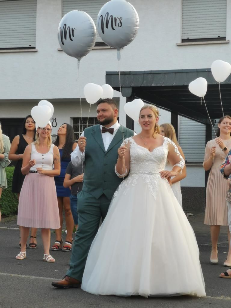 Das frisch vermählte Brautpaar Loredana und Dennis lässt nach der Trauung bunte Luftballons in den Himmel steigen.
