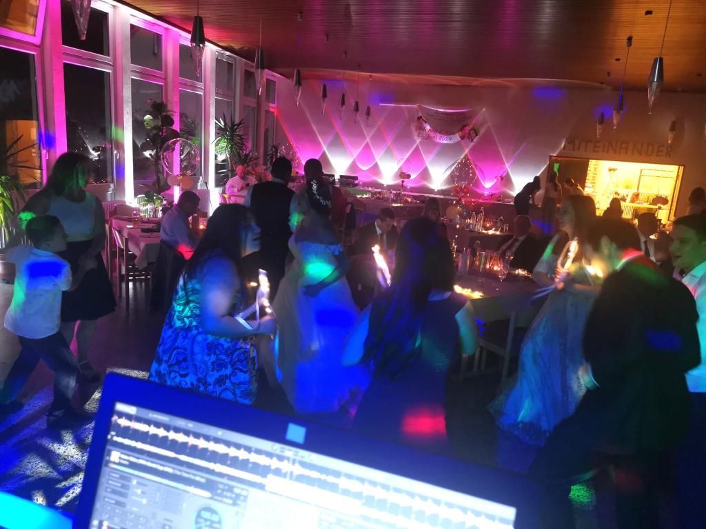 Die tanzende Hochzeitsgesellschaft perfekt in Szene gesetzt durch die bunten Floorspots von DJ Tom.