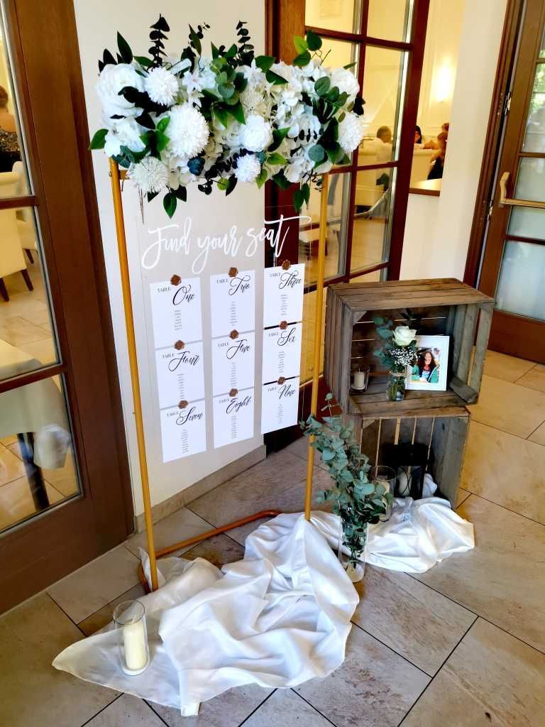 Elegante Eingangsdekoration mit Platzkarten für die Hochzeitsgäste.