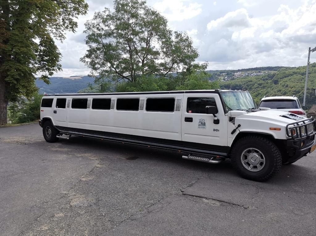 Stilechte Ankunft: Eine elegante, weiße Stretchlimousine für das Brautpaar an der Hochzeitslocation.