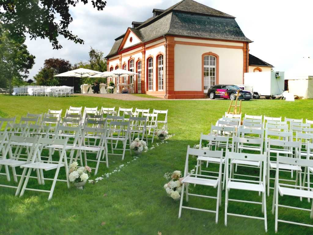 Orangerie schloss Bekond Nahaufnahme der Bestuhlung für die freie Trauung mit der Orangerie Schloss Bekond im Hintergrund.