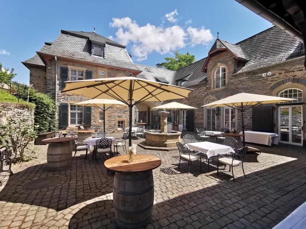 Festlich hergerichteter Innenhof der Remise mit Sonnenschirmen und Stehtischen für den Sektempfang.
