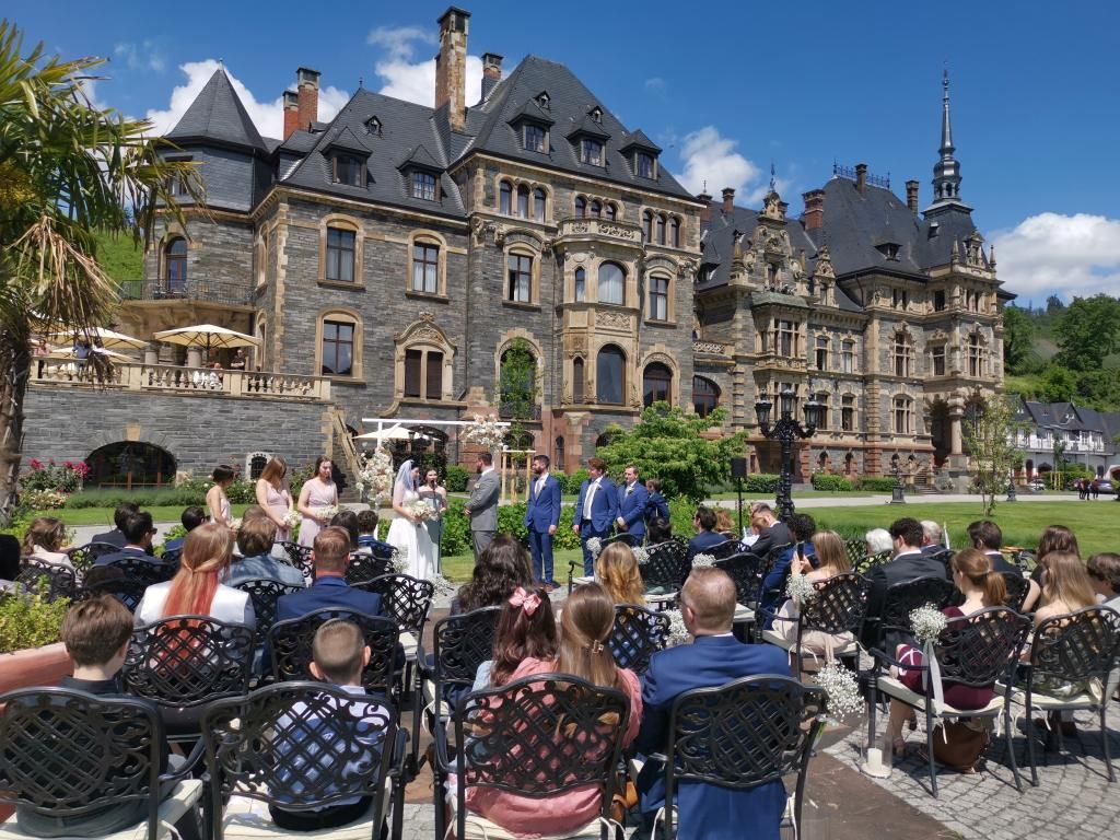 Festlich dekorierte Stühle und der Traualtar im Schlosspark von Schloss Lieser an der Mosel.
