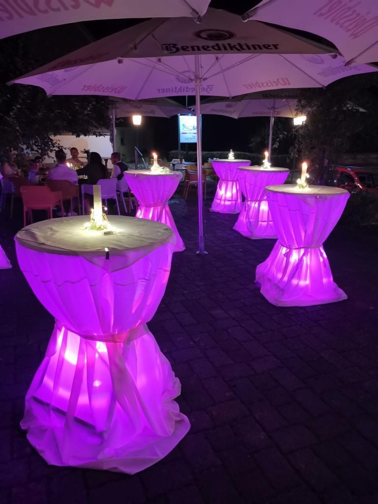 Beleuchtete Stehtische mit Hussen im Gasthaus Boes