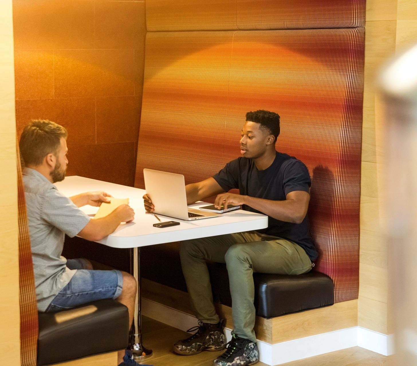 Zwei Männer sitzen zusammen und arbeiten