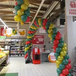 Arche et colonnes de ballons verts rouges et or entrée supermarché pour Noël fêtes fin d'année à L'Aigle Orne Normandie