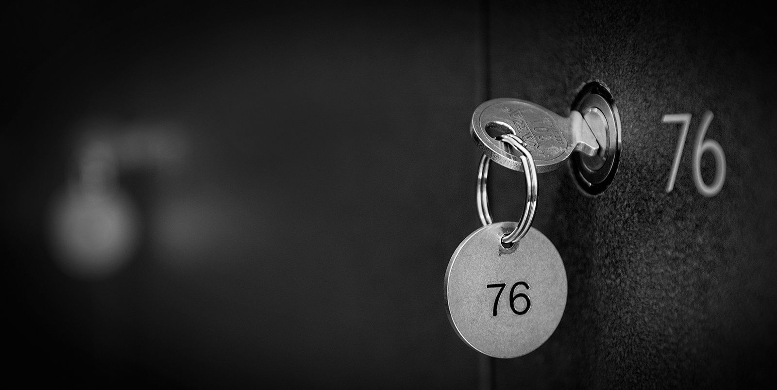A monochrome image of a locker key in the door