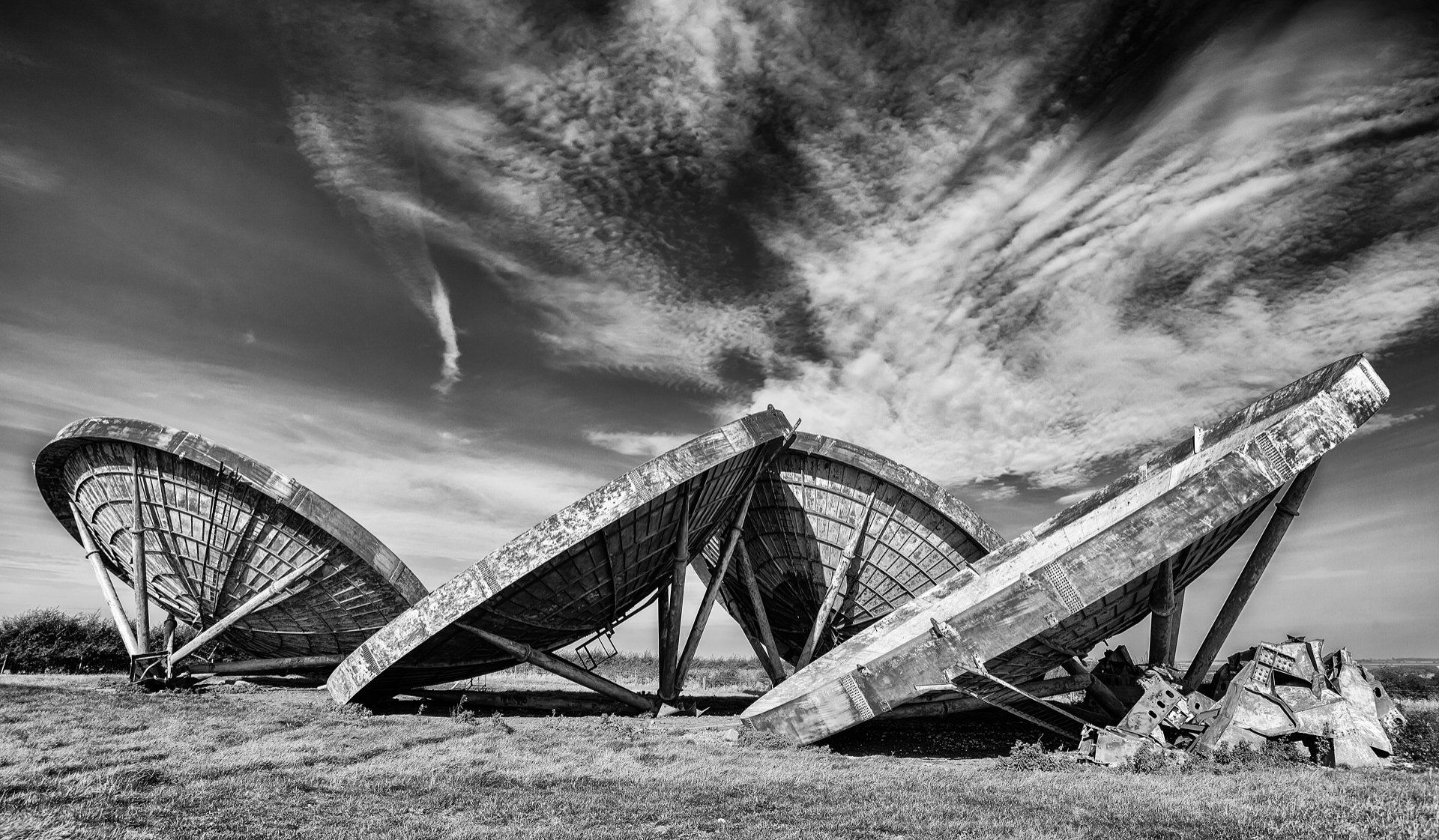 monochrome image of old radar dishes on farmland