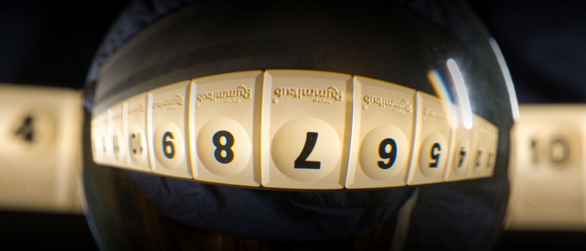 Rummikub Numbers displayed upside down using a glass sphere