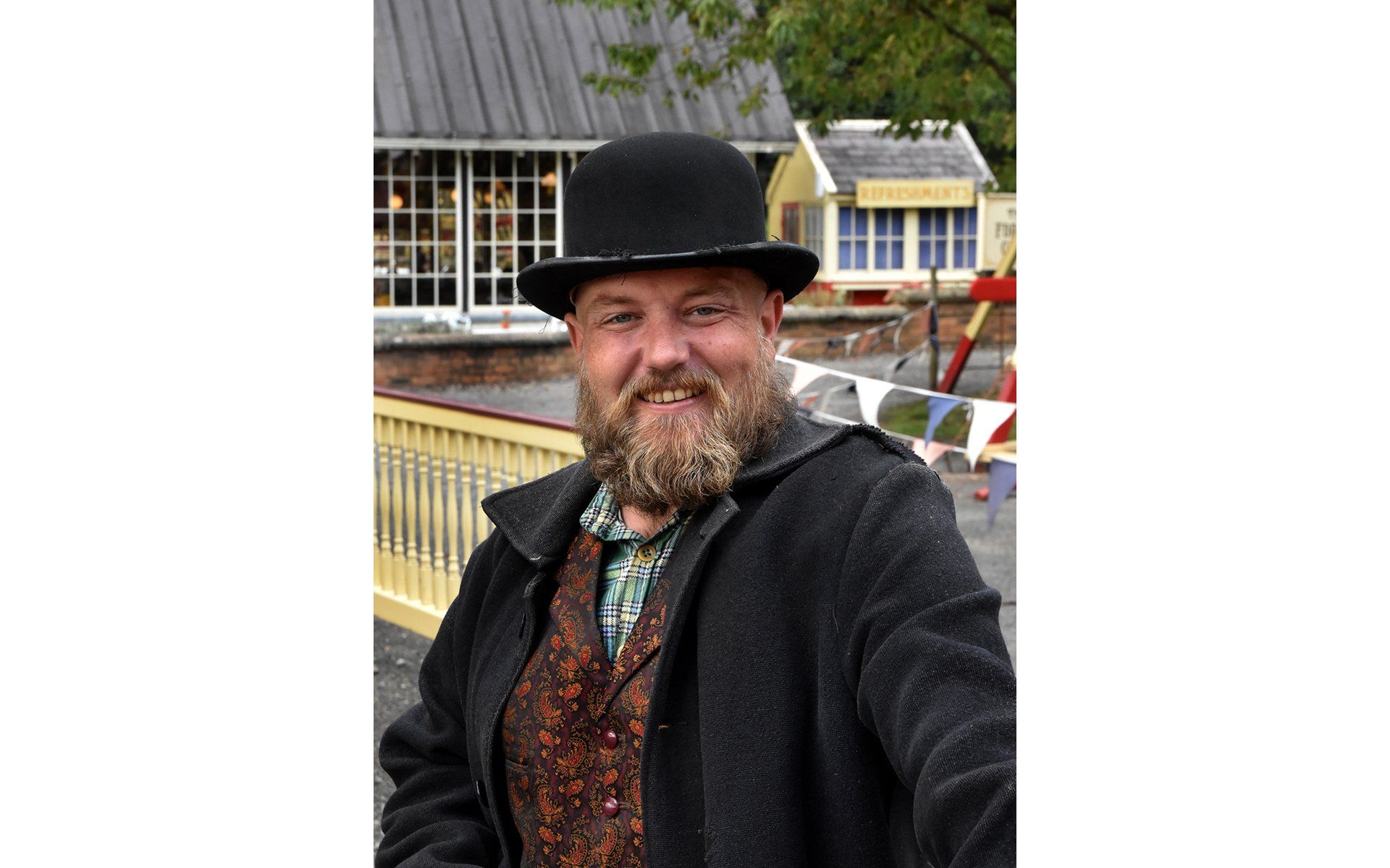 a gentleman dressed as a victorian fairground operator
