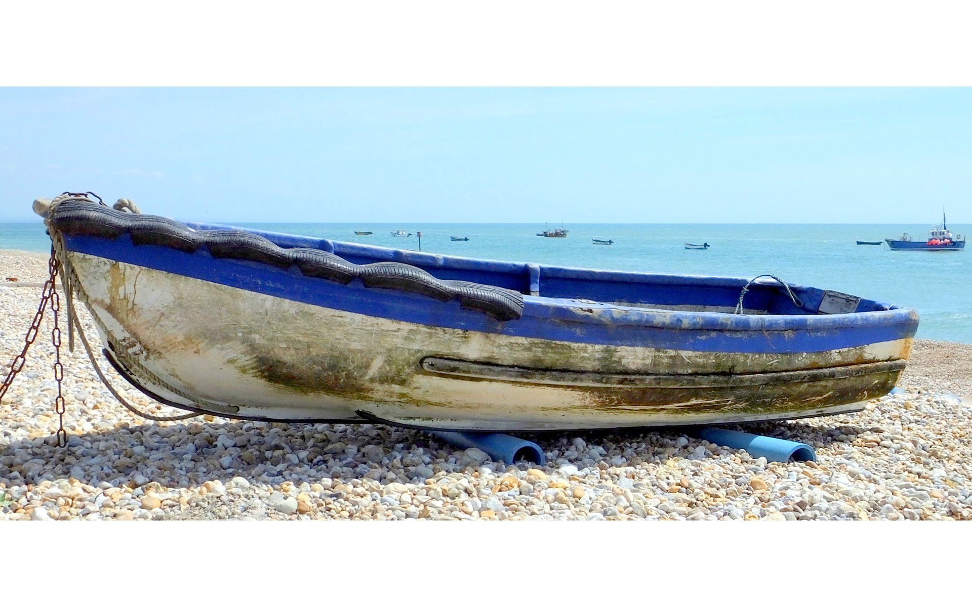 a boat pulled up onto a shingle beach