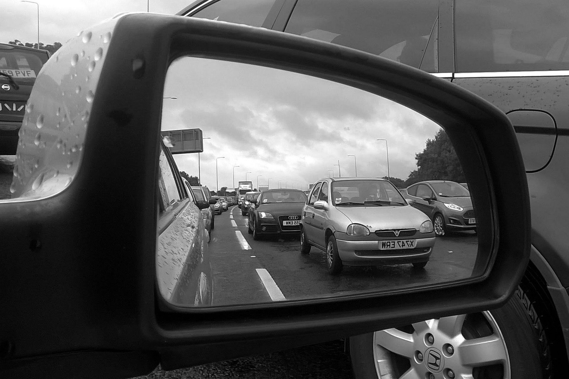 a motorway traffic jam in a rear view mirror