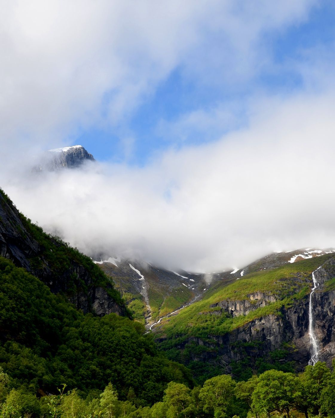 a mountain valley with clouds