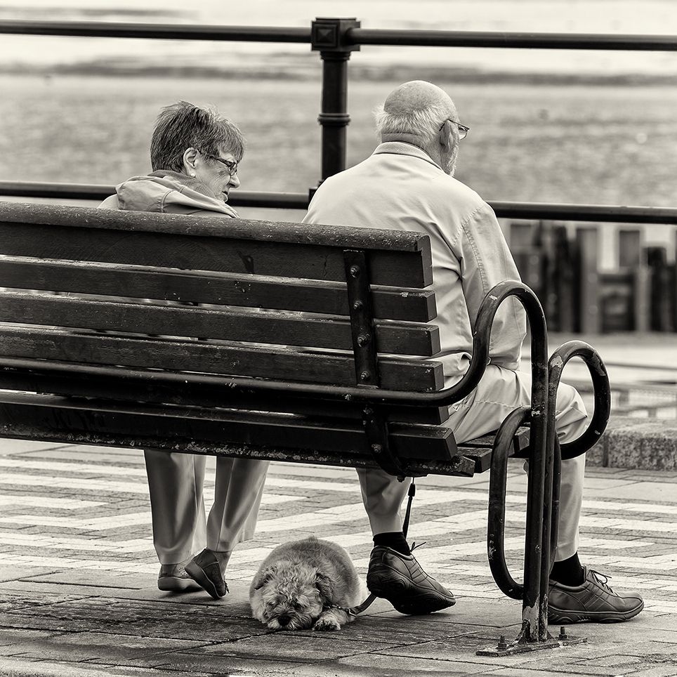 Photo by Paul Malley an older couple sitting on a bench looking out to sea