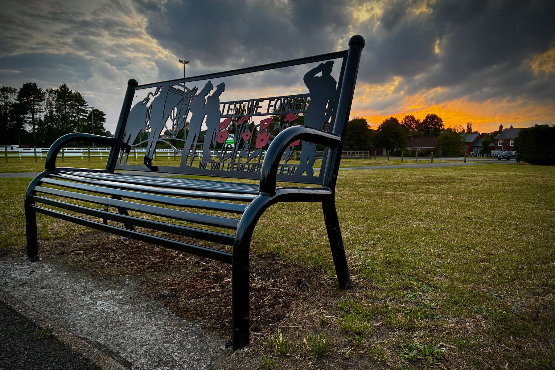 A view of sunset over a metal bench