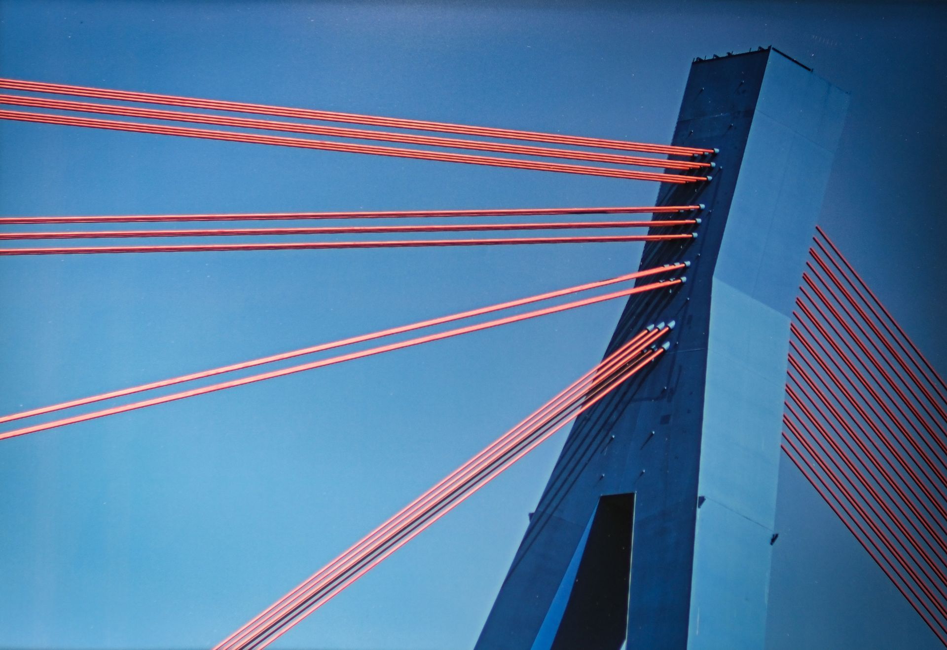 a blue bridge support with red support cables