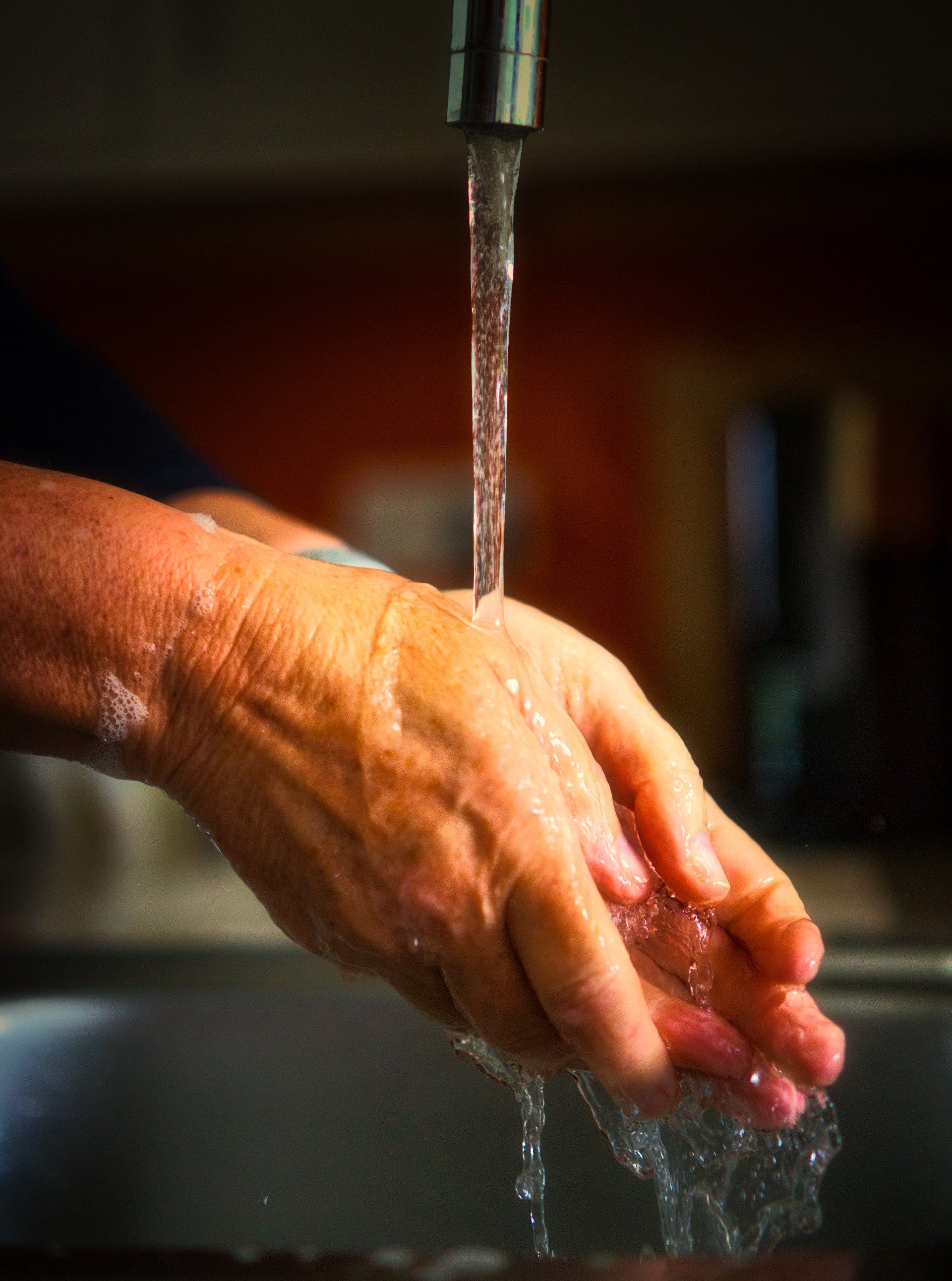 a photo of hands being washed beneath a running tap