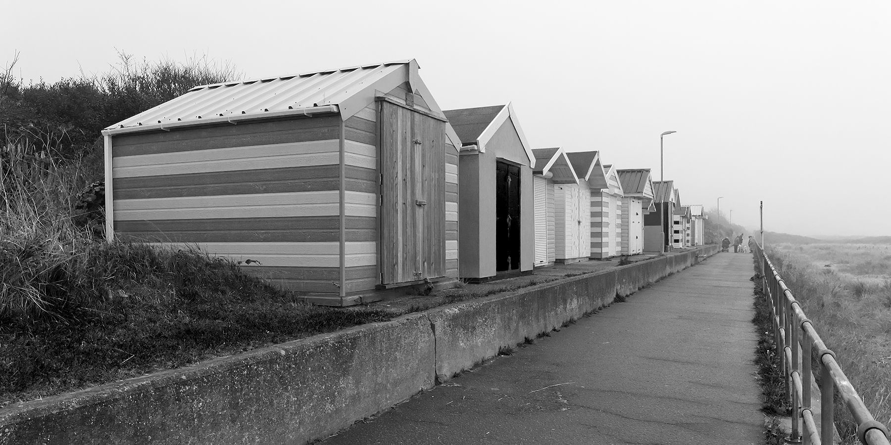 A monochrome view of a row of beach huts