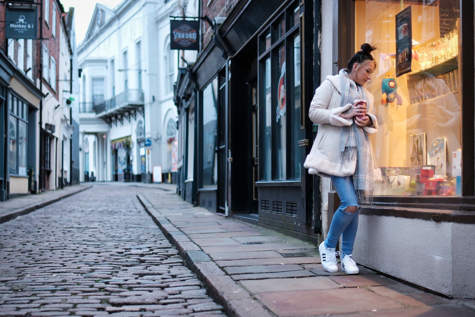 a street scene of a girl with a coffee cup