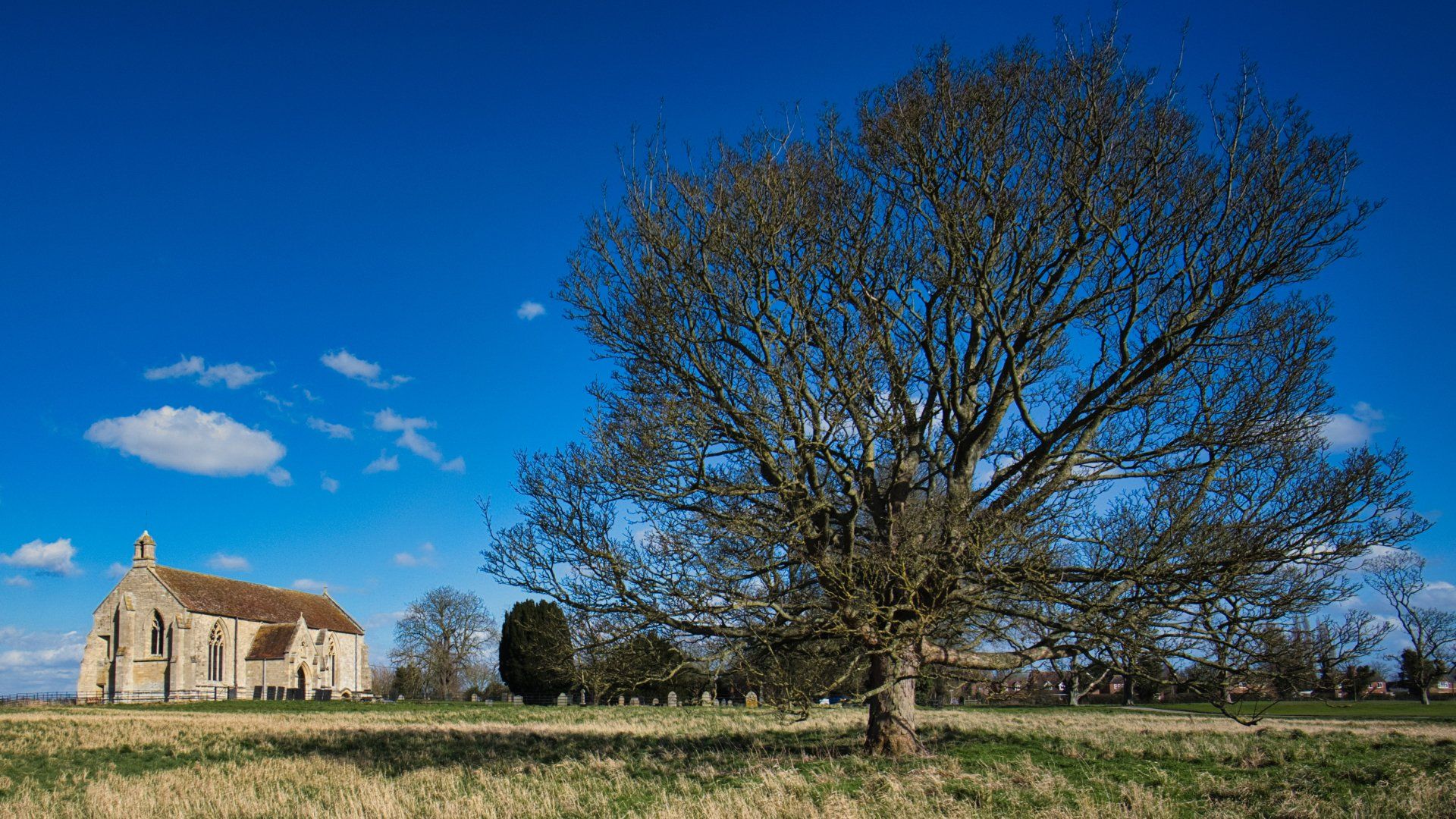 a church in a field under a blue sky
