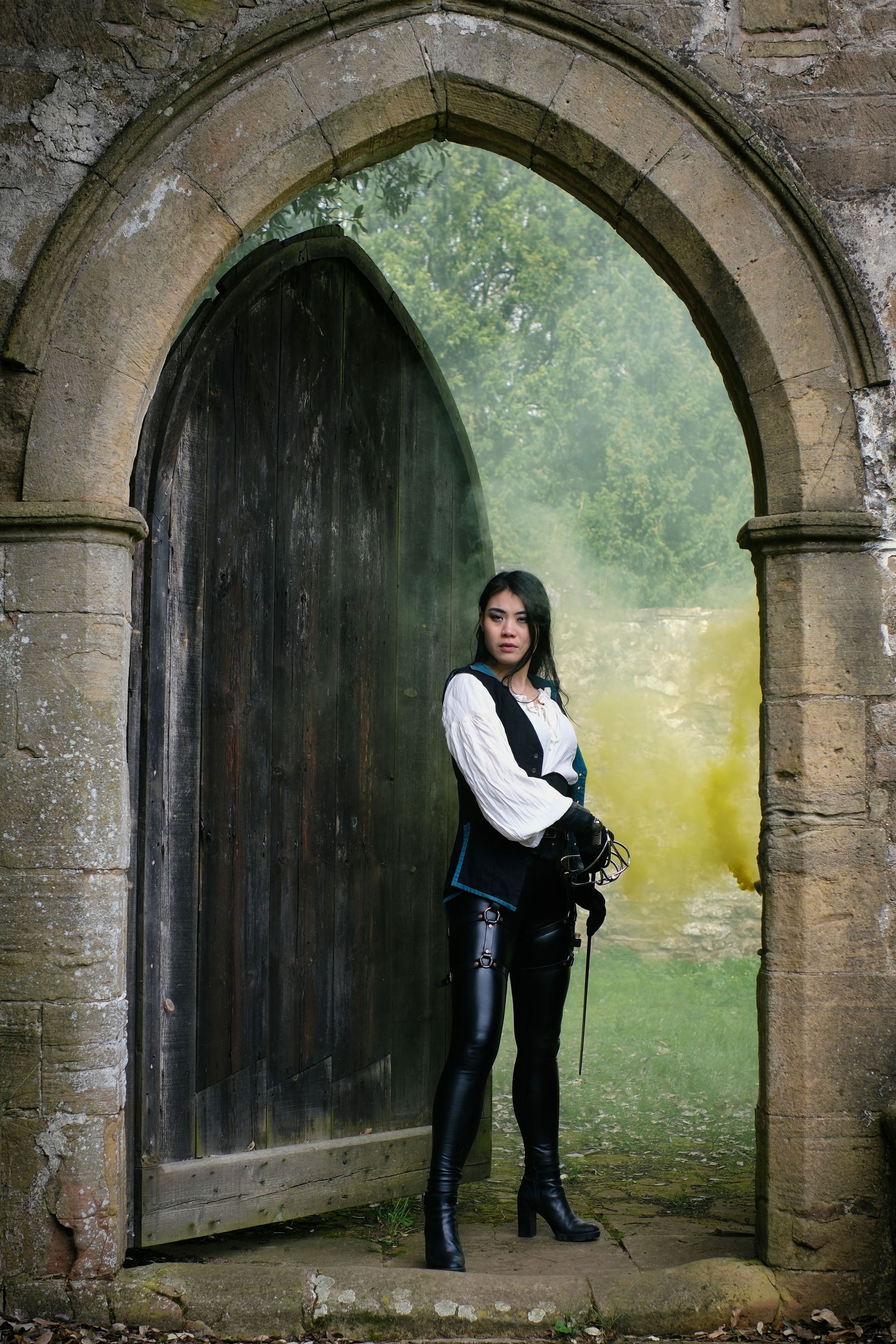 A re-enactment swordswoman in an arched doorway