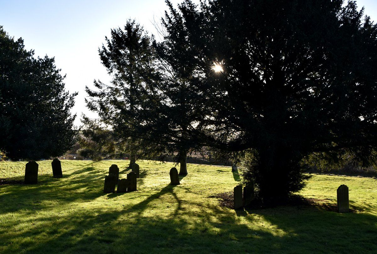 Churchyard by Graham Harrison a view of a village churchyard