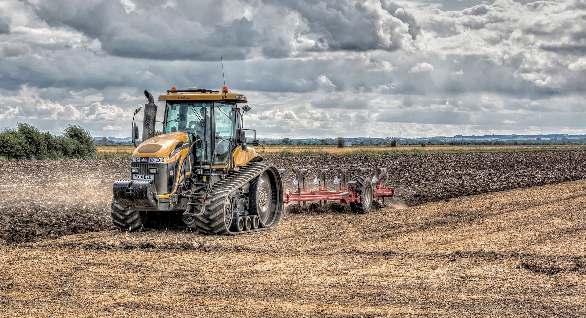 a tracked tractor ploughing a field