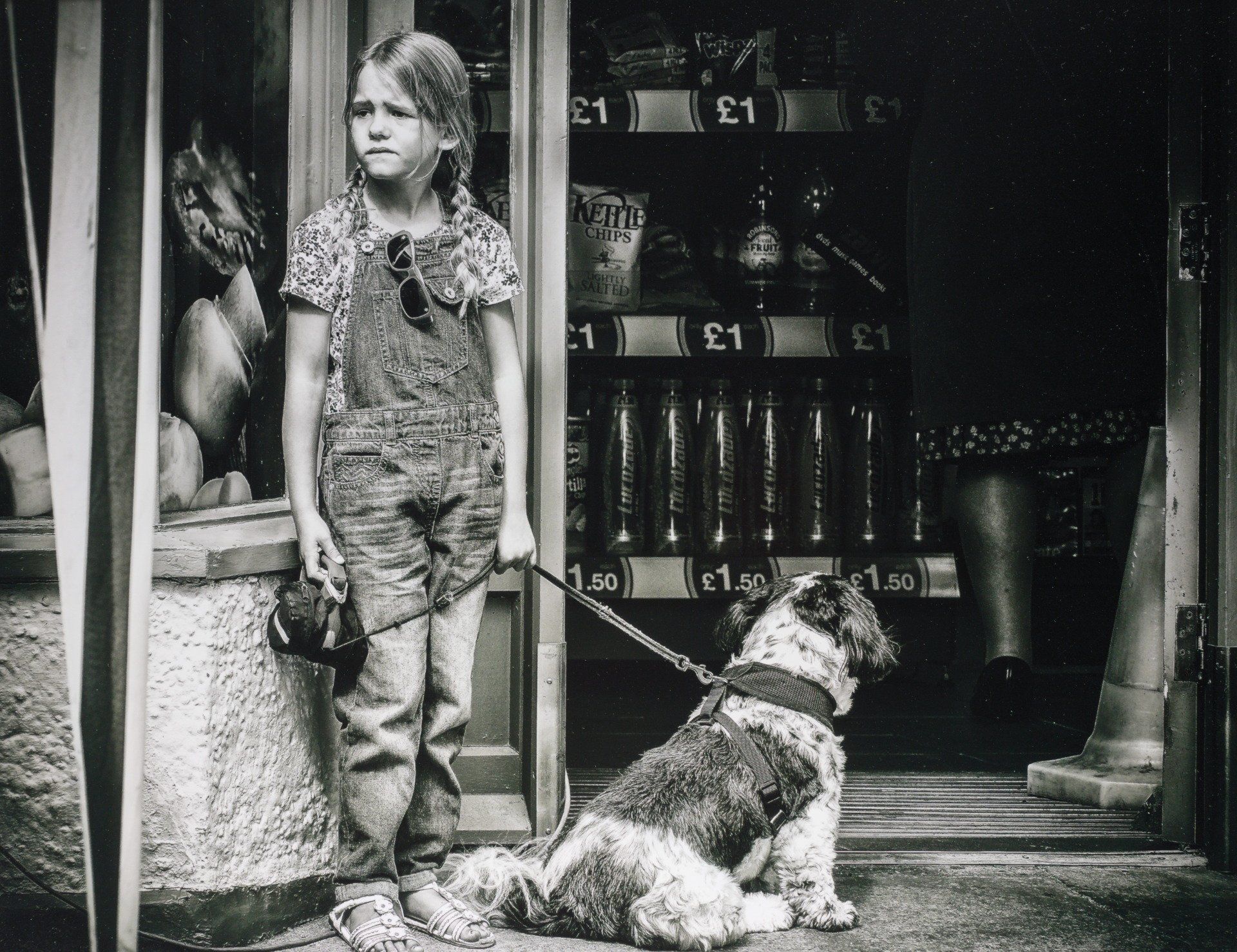 a girl and dog waiting outside a shop