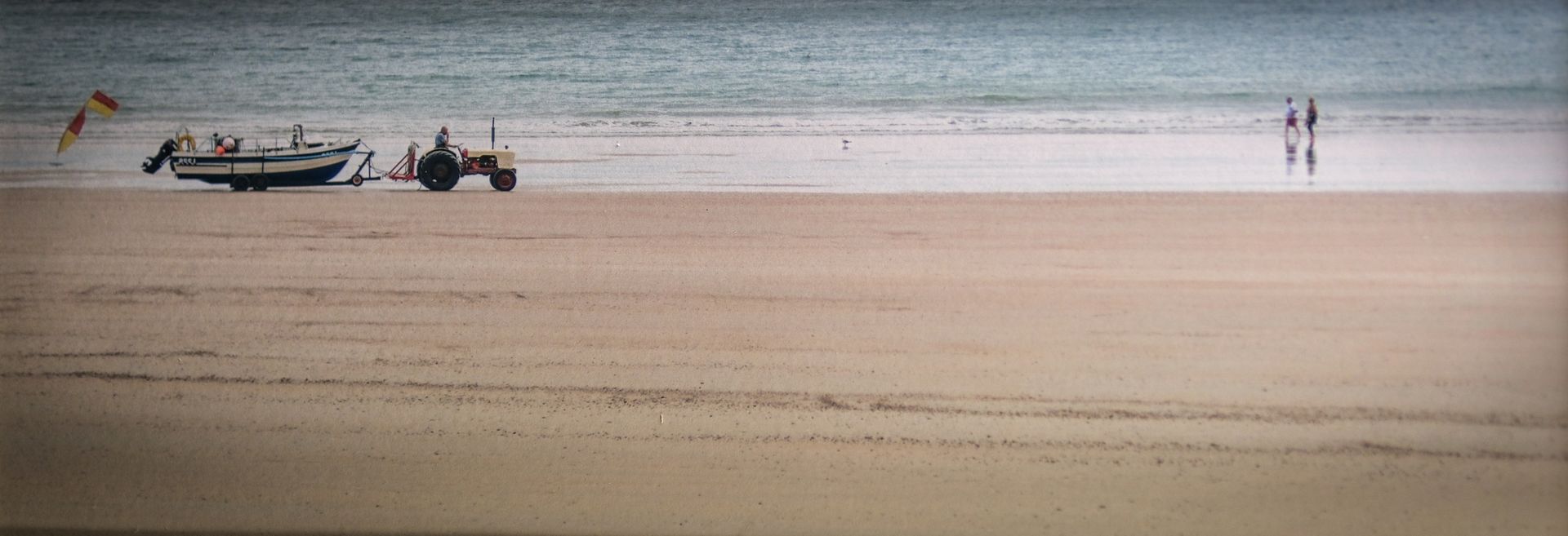 a beach scene, with a boat being towed