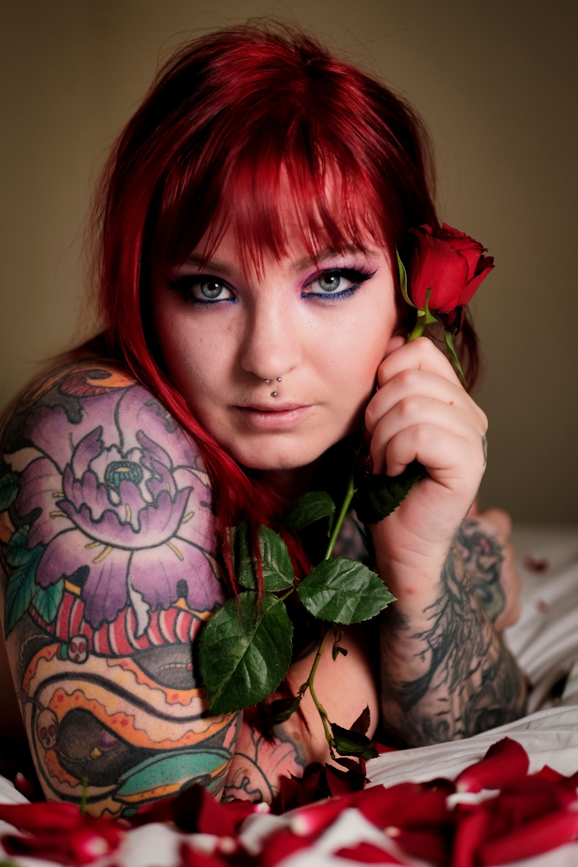 a portrait of a female model with tattoos and a rose