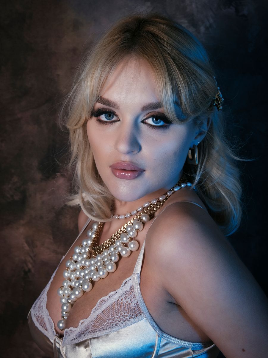 a portrait of a female model wearing pearls