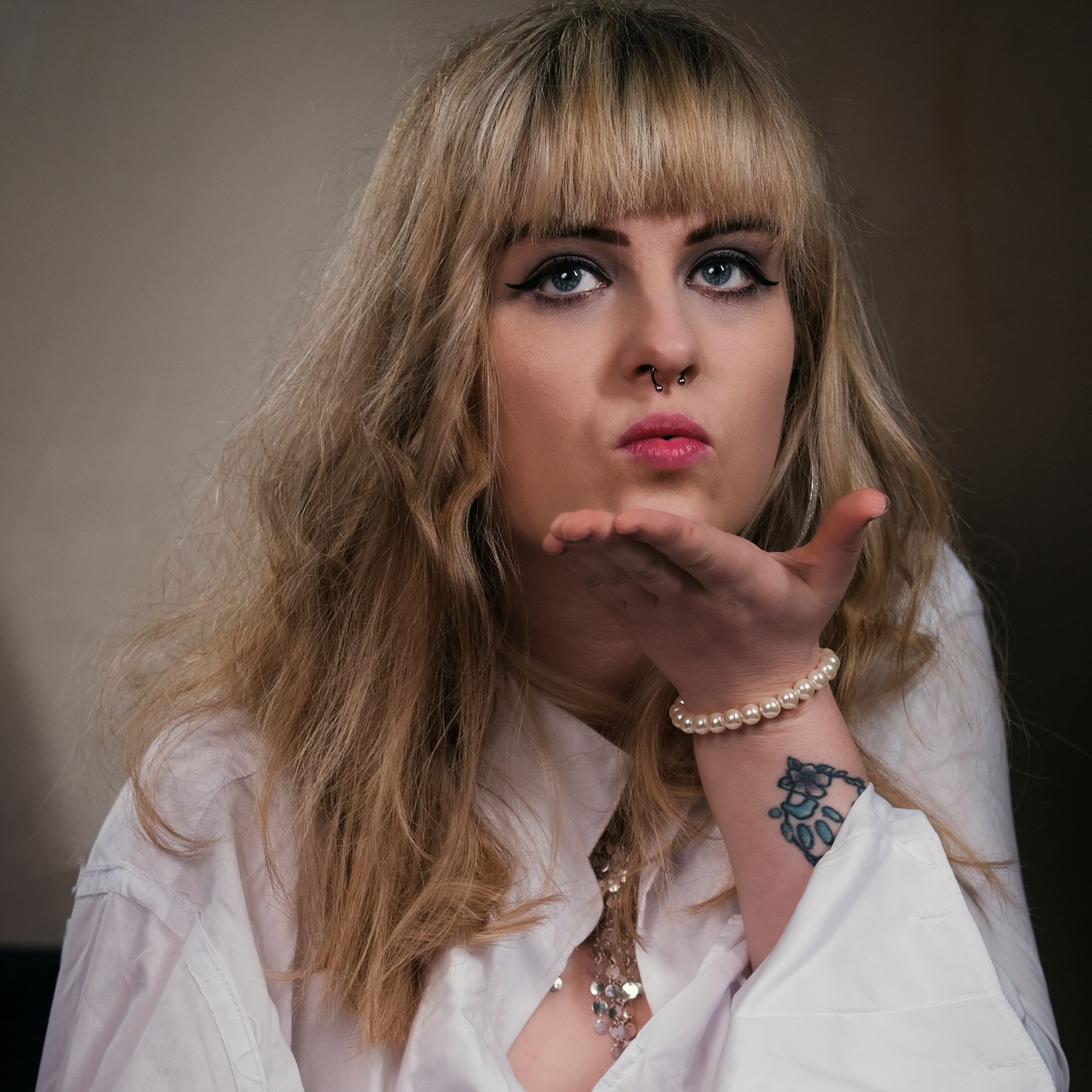 a portrait of a young model blowing a kiss