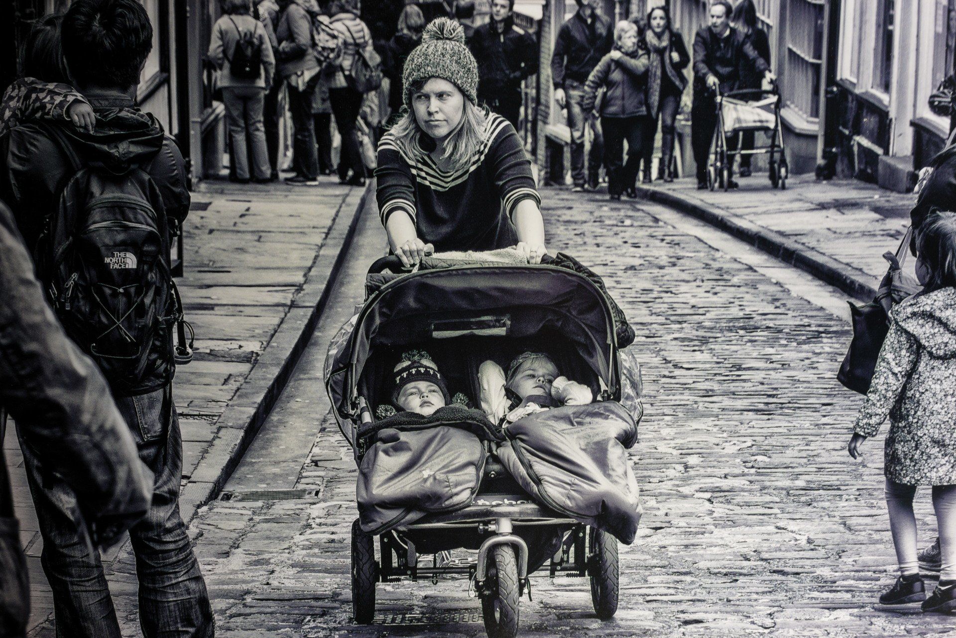 a woman pushing a pushchair to the top of a hill